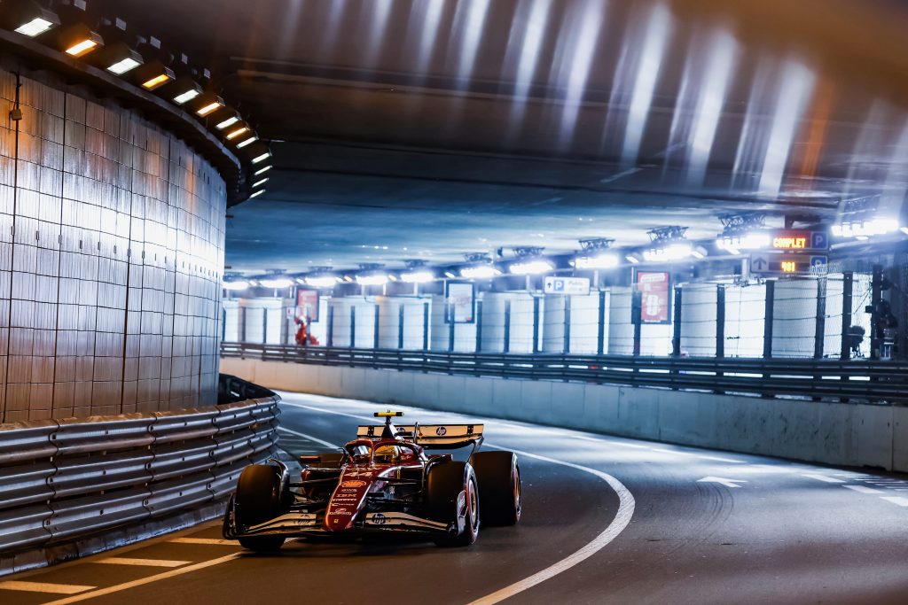 A Ferrari (red car), Lewis Hamilton’s #44, runs alone through the tunnel section, hugging the left side as it follows the curve.